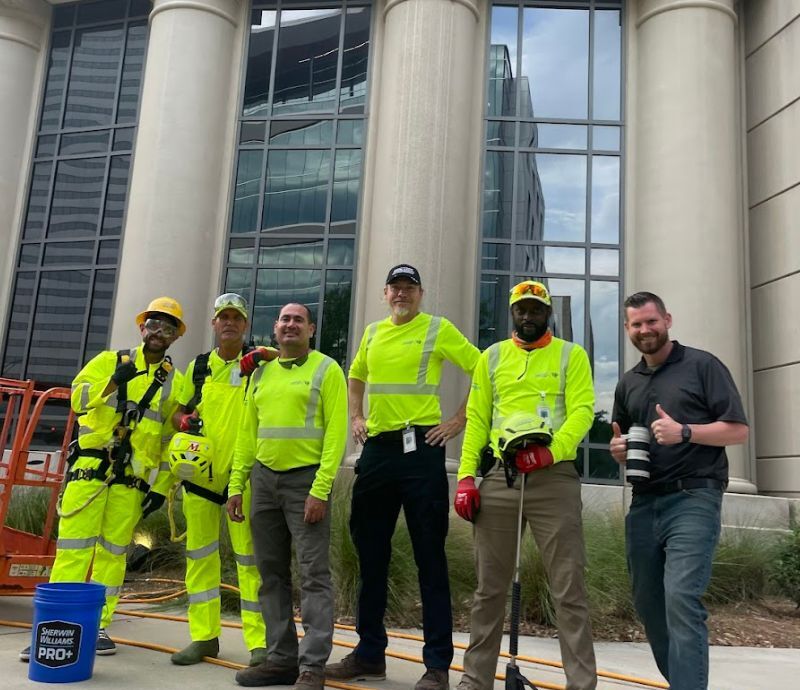 The Kept pressure washing crew in hi-vis gear outside a downtown Jacksonville building